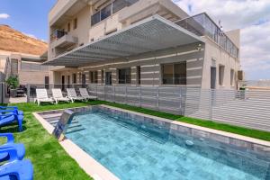 a house with a swimming pool in front of a house at וילה מינרל villa mineral in Neve Zohar