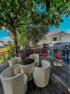 un patio con sedie, un tavolo e un albero di พูลวิลล่าเชียงใหม่ บ้านดำวัวแดง a Ban Mae Pha Haen