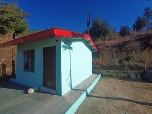a smallshed with a cat sitting in front of it at Almora Nainital-Kausani Highway Kosi Bazar in Almora +27 photos