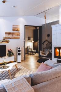 a living room with a couch and a fireplace at Villa It's Arctic Magic! in Rovaniemi