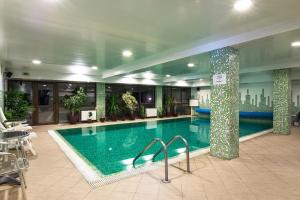 a large swimming pool in a building with a hotel at Hotel Izvor in Starozagorski Bani
