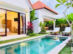 a villa with a swimming pool in front of a house at Ergio House in Tumbak Bayuh