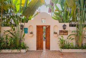 una casa con puerta de madera en un patio con plantas en ELIVAAS Bogenvilla Luxe 3 BHK Villa Near Ozran Beach, en Assagao 119 fotos más