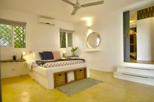 a white bedroom with a bed and a mirror at Villa Valentine LomaBonitaLasTerrenas in Las Terrenas +32 photos