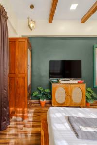 a bedroom with a bed and a tv and a cabinet at Astra by The Bombay Home Company in Mumbai