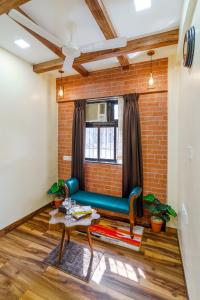 a living room with a blue couch and a brick wall at Astra by The Bombay Home Company in Mumbai