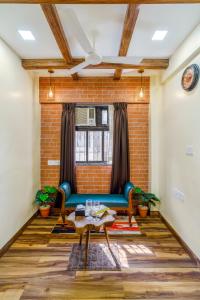 a living room with a blue couch and a brick wall at Astra by The Bombay Home Company in Mumbai