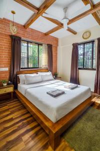 a bedroom with a large bed in a brick wall at Astra by The Bombay Home Company in Mumbai