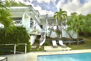 a white house with a swimming pool in front of it at Villa Valentine LomaBonitaLasTerrenas in Las Terrenas