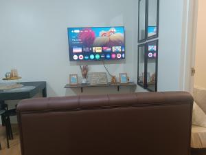 a couch in a living room with a flat screen tv at Sanremo Oasis by Beau Condotels in Cebu City +14 photos