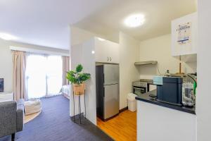a kitchen with a refrigerator and a living room at Cozy resort with free parking in CBD in Adelaide +6 photos
