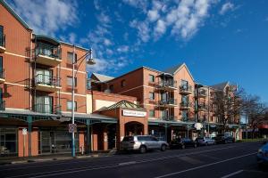 a city street with cars parked in front of buildings at Cozy resort with free parking in CBD in Adelaide