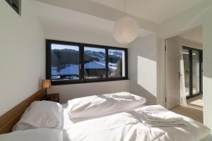 zwei Betten in einem Schlafzimmer mit Fenster in der Unterkunft Alpstein in Wildhaus