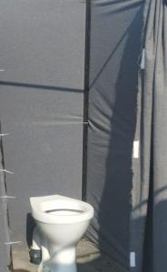 a white toilet sitting next to a wall at Tent City Prayagraj Mahakumbh in Prayagraj