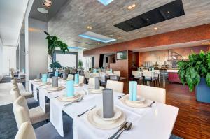 a dining room with white tables and white chairs at STEELHOUSE Hotel in Třinec