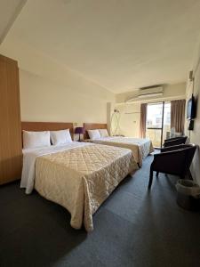 una camera d'albergo con due letti e una finestra di Chian Huei Business Hotel a Taipei