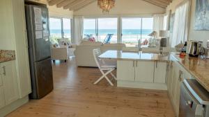 una cucina con tavolo e vista sull'oceano di Beach house, Cannon Rocks, near Kenton-on-Sea a Cannon Rocks