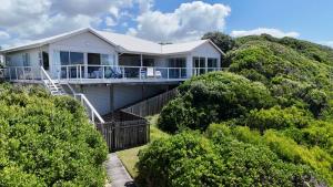 una casa bianca in cima a una collina con alberi di Beach house, Cannon Rocks, near Kenton-on-Sea a Cannon Rocks