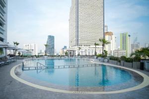 a large swimming pool in the middle of a city at Centre Point Plus Hotel Silom - Newly Renovated in Bangkok