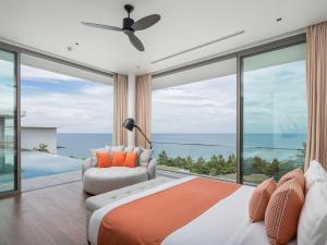 ein Schlafzimmer mit Bett und Blick auf das Meer in der Unterkunft Malaiwana Residences in Nai Thon Beach