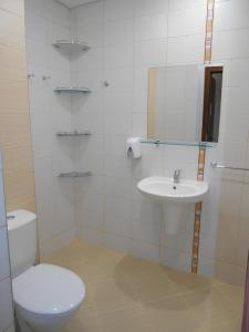 a white bathroom with a toilet and a sink at NEAT STUDIOS in "BOROVETS GARDENS" hotel in Borovets