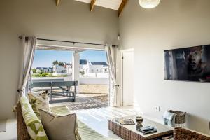 a living room with a couch and a tv at Perlemoentjie in Britannia Bay