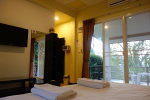 um quarto com uma cama e uma grande janela em Khaolak Hillside Villa em Khao Lak