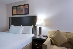 Voodi või voodid majutusasutuse Travelodge by Wyndham Kamloops Mountview toas