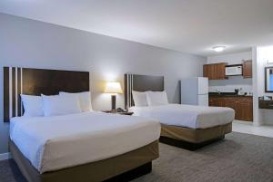Voodi või voodid majutusasutuse Travelodge by Wyndham Kamloops Mountview toas