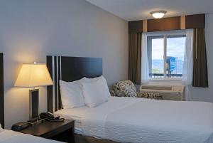 Voodi või voodid majutusasutuse Travelodge by Wyndham Kamloops Mountview toas