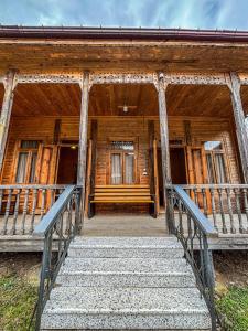 a wooden house with stairs in front of it at Gomi Riverside in Gomi