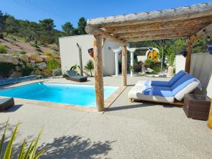 a swimming pool with a pergola next to a house at La demeure d'Aphrodite in Babeau-Bouldoux