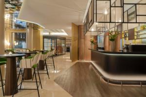 a restaurant with a bar and tables and chairs at NH Collection Buenos Aires Jousten in Buenos Aires