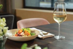 a bowl of salad and a glass of wine on a table at NH Collection Buenos Aires Jousten in Buenos Aires