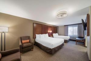 a hotel room with two beds and a chair at Comfort Suites Red Bluff near I-5 in Red Bluff