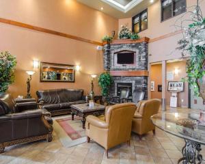 a living room with leather furniture and a fireplace at Quality Inn & Suites in Grande Prairie