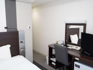 a bedroom with a desk with a bed and a mirror at Comfort Hotel Tokyo Kanda in Tokyo