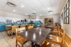 Un restaurante con mesas y sillas y un mostrador. en Country Inn & Suites by Radisson, Watertown, SD, en Watertown