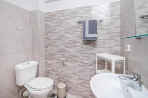 a bathroom with a white toilet and a sink at Silia apartments 3 in Ampavris