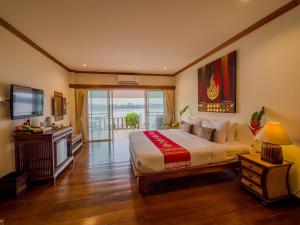 a bedroom with a large bed and a television at Chiangkhan River Mountain Resort in Chiang Khan