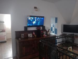 ein Wohnzimmer mit einem Flachbildfernseher an der Wand in der Unterkunft Leonardo GuestHouse Available in Sibiu