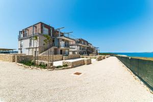a house on the beach next to the ocean at Novaedil Apartment in Povljana