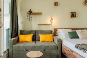 a bedroom with a couch and a bed with yellow pillows at Le Lagon Vert in Saint-François