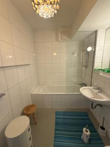 a bathroom with a tub and a sink and a toilet at Kaiserteich Wohnung in Düsseldorf