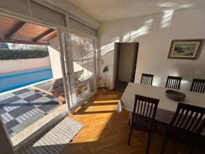 a dining room with a table and a balcony at Apartman Surya Medulin in Medulin