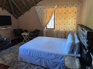 a bedroom with a bed with blue sheets and a window at VM Guesthouse in Hazyview +61 photos