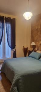 Un dormitorio con una cama con sábanas azules y una ventana. en La Rosa 19, en Castilleja de la Cuesta