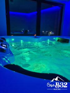 a jacuzzi tub in a room with blue lights at Casa B32 Spa Rucar in Rucăr