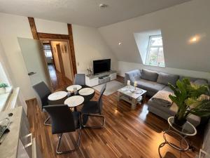 a living room with a couch and a table and chairs at Ferienwohnung Mittweida-City "Schacherhaus" - direkt im Stadtzentrum der Hochschulstadt Mittweida in Mittweida