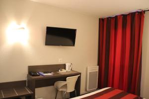 アンデルナンにあるThe Originals City, Hôtel Le Louisiane, Belfort Sudの机と赤いカーテンのあるホテルの部屋